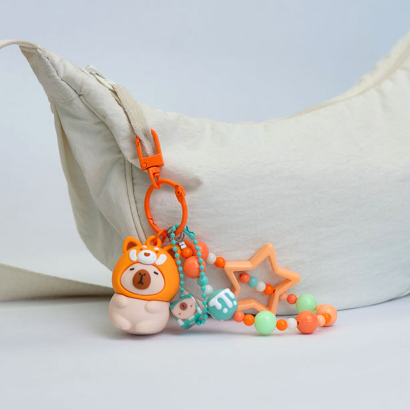 Portachiavi capibara con cappuccio da animaletto kawaii disponibile in 4 varianti: capibara apetta, capibara panda, capibara rana, capibara volpina.