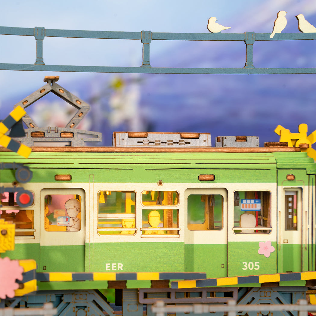 Puzzle in 3d che riproduce la stazione di un tram vicino ad un albero di ciliegio in fiore.