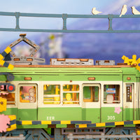 Puzzle in 3d che riproduce la stazione di un tram vicino ad un albero di ciliegio in fiore.