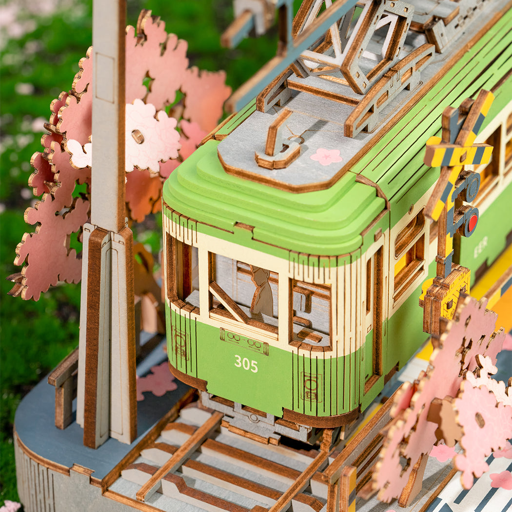 Puzzle in 3d che riproduce la stazione di un tram vicino ad un albero di ciliegio in fiore.