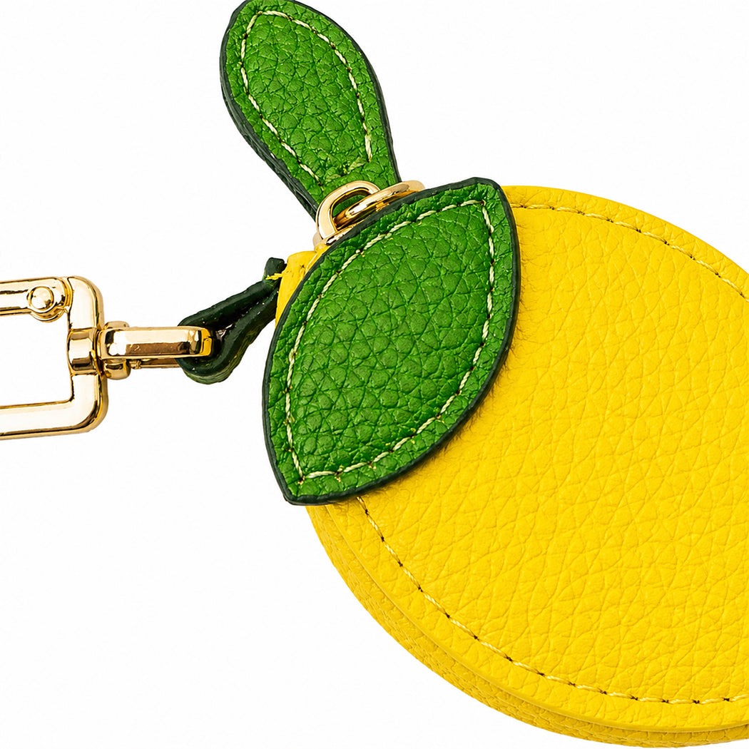 Portachiavi a forma di limone. Ha una piccola tasca richiudibile con zip.