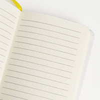 Notebook  formato A6 con copertina rigida e chiusura ad elastico. Sulla copertina e sul retro sono disegnati dei girasoli e delle apette.