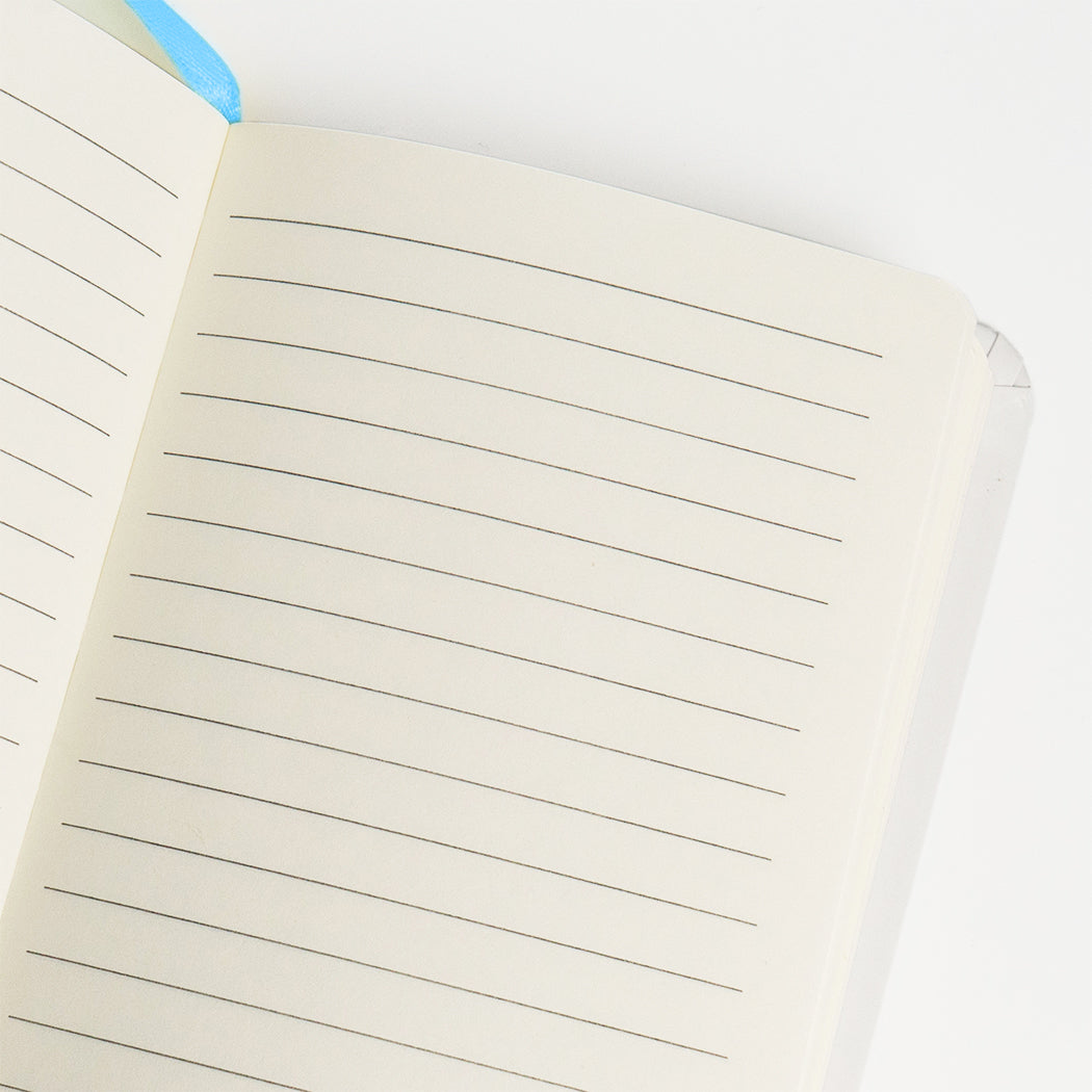 Notebook  formato A6 con copertina rigida e chiusura ad elastico.
Sulla copertina e sul retro sono disegnati dei tulipani blu e delle apette.