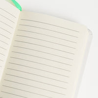 Notebook  formato A6 con copertina rigida e chiusura ad elastico.
Sulla copertina e sul retro sono disegnati dei fiori di hibiscus e delle apette.