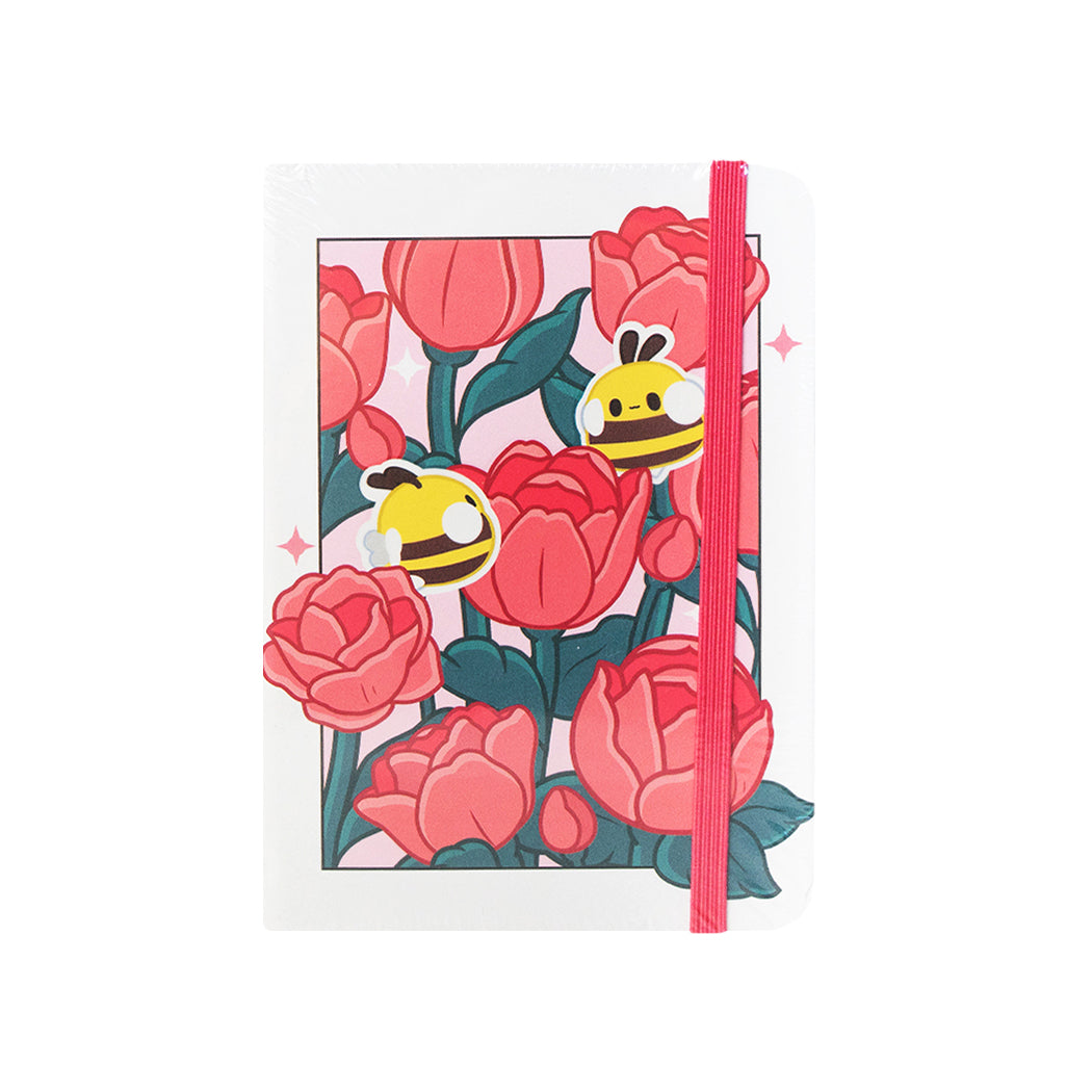 Notebook  formato A6 con copertina rigida e chiusura ad elastico.
Sulla copertina e sul retro sono disegnate delle rose e delle apette.