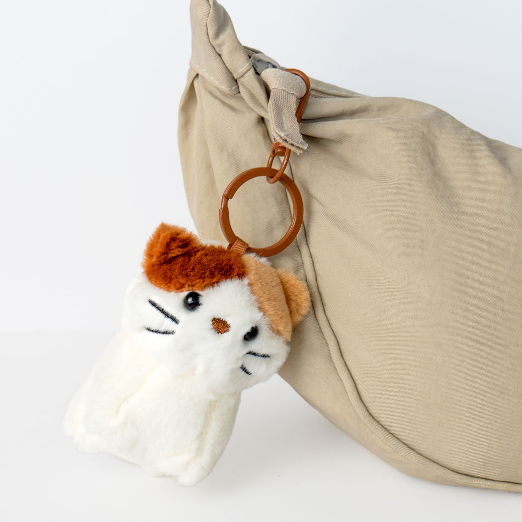Portachiavi plush duo a forma di gattino che tiene un pesciolino in bocca.